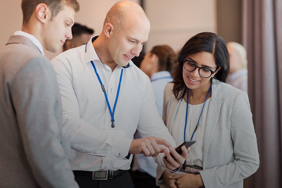 couple with smartphone at business conference